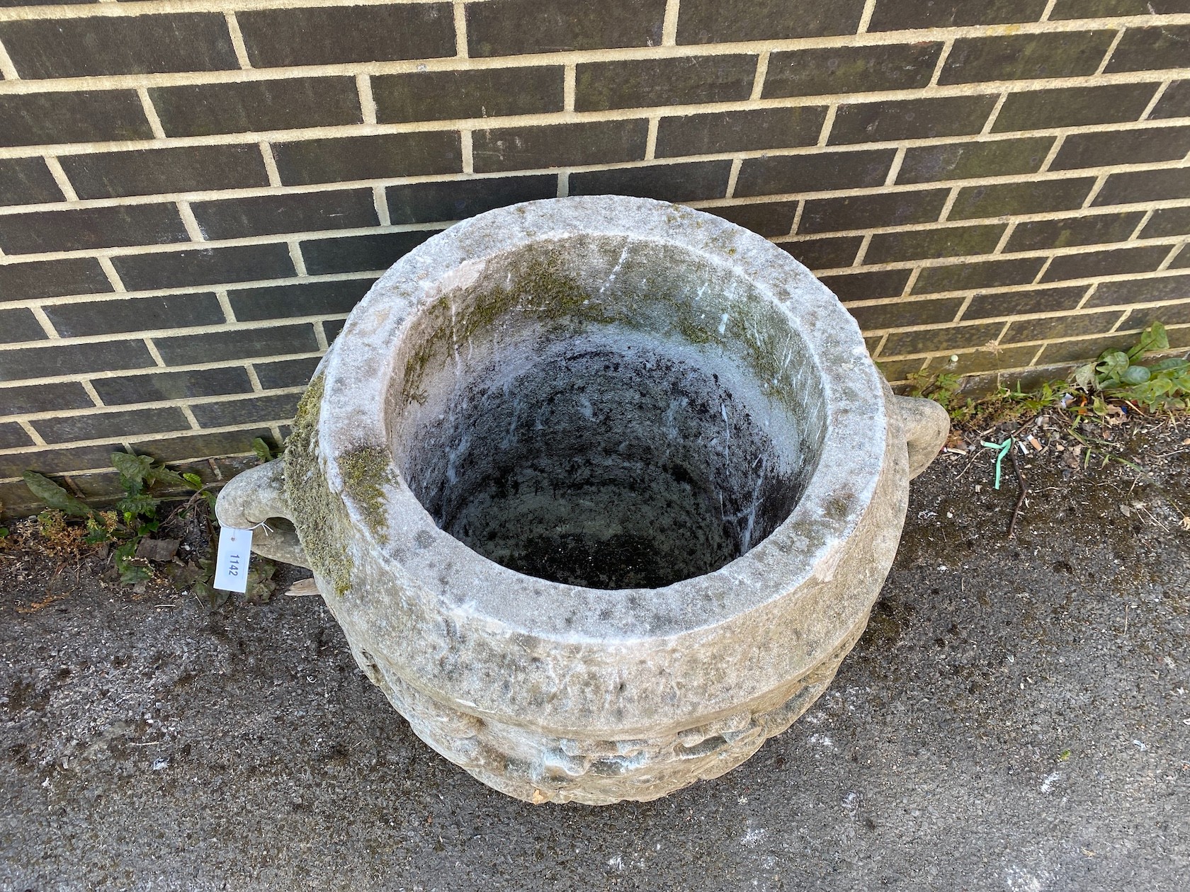 A large circular reconstituted stone garden planter with moulded serpent armorial, diameter 66cm, height 66cm